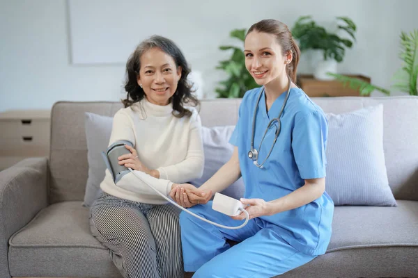 stock image Portrait of female doctor measuring patients blood pressure before treatment