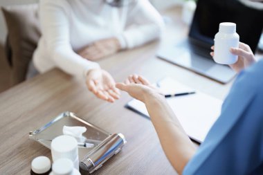 Yaşlı bir hastaya ilaç veren bir kadın doktorun portresi.