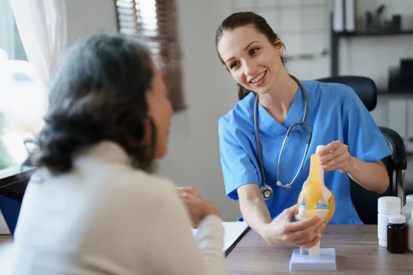 stock image Portrait of a female doctor talking to an elderly patient about osteoarthritis