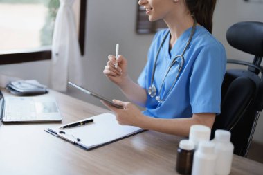Tablet bilgisayar kullanan bir kadın doktorun portresi ve tedavi öncesi bir hastanın durumunu analiz eden bir belge
