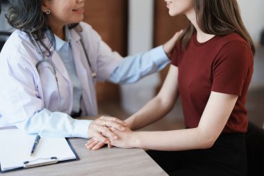 Hastalığa karşı savaşmak için hastaların elini tutan bir kadın doktorun portresi.