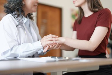 Hastalığa karşı savaşmak için hastaların elini tutan bir kadın doktorun portresi.