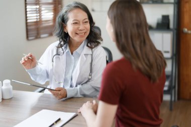 Hasta durumunu tartışmak ve analiz etmek için elinde tablet olan bir kadın doktorun portresi