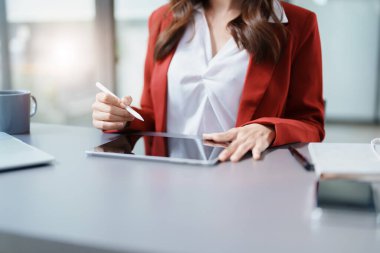 İş yeri sahibi ya da Asyalı kadın pazarlamacılar ofis çalışmalarında tablet bilgisayar kullanıyorlar.