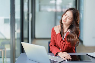 Uzun süre oturmaktan omuz ağrısı çeken genç Asyalı kadın temsilcinin portresi..