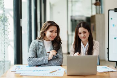 Şirket toplantıları sırasında planlanan yatırım projeleriyle ilgili iş raporlarını analiz eden mali analistler pazarlama planı, bilgisayarlar ve hesap makineleriyle başarılı bir takım çalışması sergilediler..