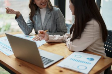 Şirket toplantıları sırasında planlanan yatırım projeleriyle ilgili iş raporlarını analiz eden mali analistler pazarlama planı, bilgisayarlar ve hesap makineleriyle başarılı bir takım çalışması sergilediler..