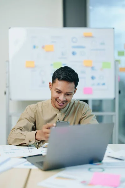 stock image business owner or Asian male marketers are using business phones and computers to do office work.