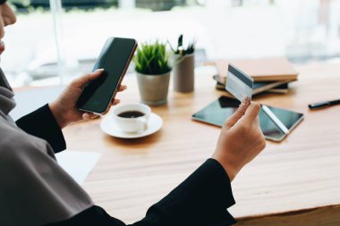 Güzel Müslüman kadın internetten telefon ve kredi kartıyla alışveriş yapıyor..