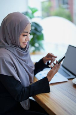 Güzel Müslüman kadın internetten telefon ve kredi kartıyla alışveriş yapıyor..