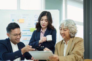 Asyalı girişimciler ve iş adamları iş planlaması, mali bütçe ve yatırım risk değerlendirmesi konularında bir konferans salonunda bir araya gelerek müşteri gruplarının şirket büyümesini artırmak için analiz ediyorlar..