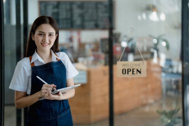 Başlangıçta başarılı olan küçük işletme sahibi, elinde tabletle kafede duran, Asyalı esmer kadın kafe sahibi, girişimci iş adamı konsepti..