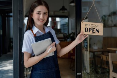 Başlangıçta başarılı olan küçük işletme sahibi, elinde tabletle kafede duran, Asyalı esmer kadın kafe sahibi, girişimci iş adamı konsepti..