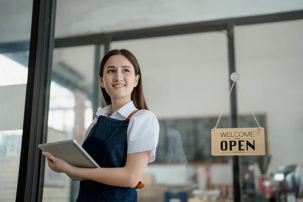 Startup successful small business owner sme beauty girl stand with tablet in coffee shop restaurant, asian tan woman barista cafe owner, entrepreneur seller business concept.
