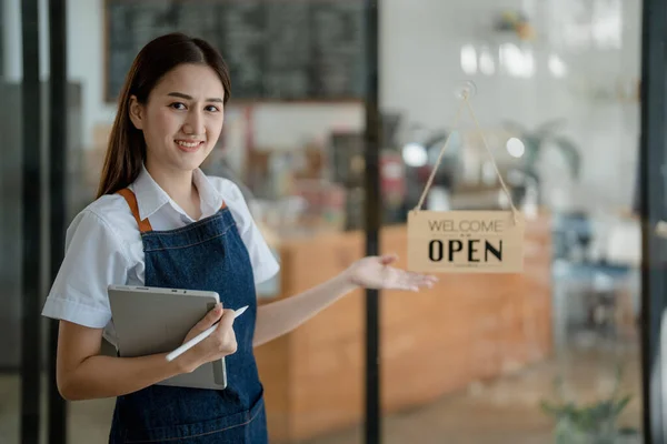 Startup successful small business owner sme beauty girl stand with tablet in coffee shop restaurant, asian tan woman barista cafe owner, entrepreneur seller business concept.