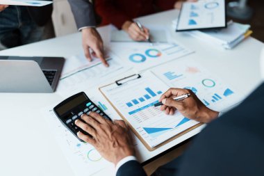 Toplantı odasındaki mali raporda durumu analiz etmek ve tartışmak için hesap makinesi, doküman, bilgisayar bilgisayarı kullanarak takım danışmanlığı toplantısı.