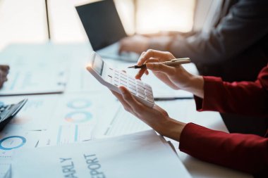 Toplantı odasındaki mali raporda durumu analiz etmek ve tartışmak için hesap makinesi, doküman, bilgisayar bilgisayarı kullanarak takım danışmanlığı toplantısı.