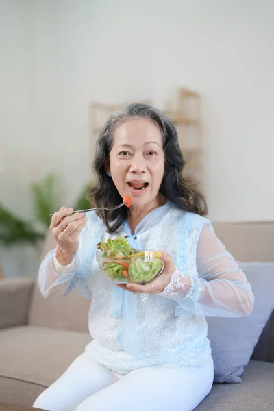 stock image Portrait of an elderly Asian woman taking care of her health by eating salad