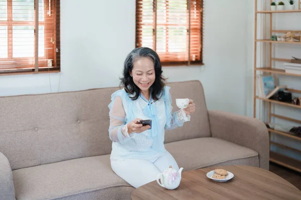 Retrato Una Anciana Asiática Sosteniendo Teléfono Móvil Con Aperitivos Tomando —  Fotos de Stock