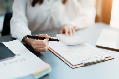 Muhasebeciler ve Asyalı denetçiler vergi bütçelerini gözden geçirmek için hesap makineleri ve bilgisayarlar kullanarak vergi dairesine bilgi gönderiyorlar.