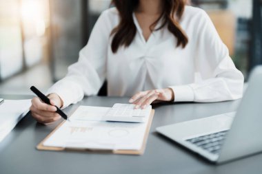 Muhasebeciler ve Asyalı denetçiler vergi bütçelerini gözden geçirmek için hesap makineleri ve bilgisayarlar kullanarak vergi dairesine bilgi gönderiyorlar.