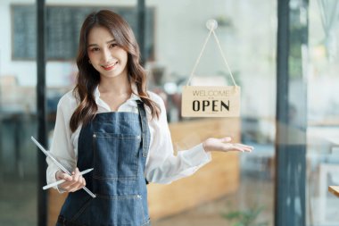 Kafenin önünde elinde tabletle mutlu bir Asyalı kadının portresini aç.