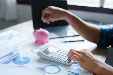 KOBİ operasyonlarından elde ettiği birikimleri hesaplamak için hesap makinesi kullanan Asyalı bir işadamının portresi..