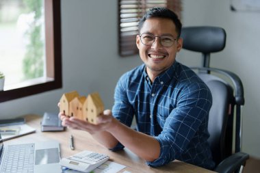 Entrepreneurs, business owners, accountants, real estate agents, A young man using a calculator to calculate his home budget to assess the risks of investing in real estate.