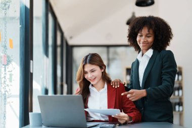 Çok ırklı bir iş, Asyalı iş kadınlarıyla buluşan güzel bir Amerikalı Afrikalı. Muhasebeciler belge, vergi, döviz, muhasebe ve mali danışmanlık yaparlar..