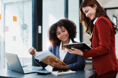 Çok ırklı bir iş, Asyalı iş kadınlarıyla buluşan güzel bir Amerikalı Afrikalı. Muhasebeciler belge, vergi, döviz, muhasebe ve mali danışmanlık yaparlar..