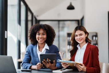 Çok ırklı bir iş, Asyalı iş kadınlarıyla buluşan güzel bir Amerikalı Afrikalı. Muhasebeciler belge, vergi, döviz, muhasebe ve mali danışmanlık yaparlar..