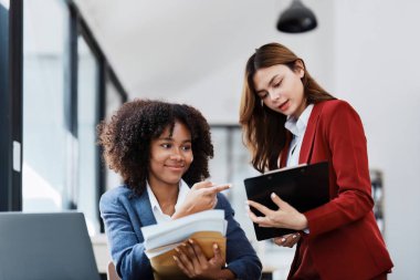 Çok ırklı bir iş, Asyalı iş kadınlarıyla buluşan güzel bir Amerikalı Afrikalı. Muhasebeciler belge, vergi, döviz, muhasebe ve mali danışmanlık yaparlar..