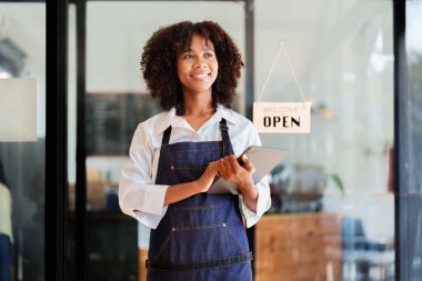 Başlangıçta başarılı, küçük, güzel, Afrikalı, güzel bir kız kahve dükkanında tabletle duruyor. Girişimci iş konsepti..