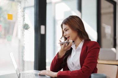 Güzel genç Asyalı iş kadını bilgisayar ve akıllı telefon kullanıyor mali belge, vergi, döviz, muhasebe ve mali danışman üzerinde çalışıyor..