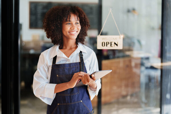 Startup successful small Beautiful American African owner sme beauty girl stand with tablet in coffee shop restaurant, entrepreneur seller business concept.