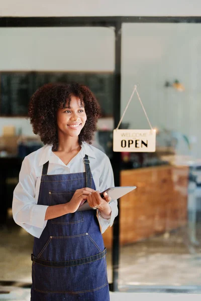 stock image Startup successful small Beautiful American African owner sme beauty girl stand with tablet in coffee shop restaurant, entrepreneur seller business concept.