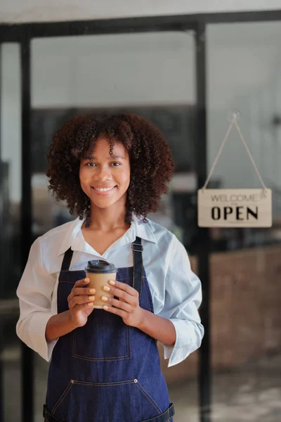 Startup successful small Beautiful American African owner sme beauty girl stand holding coffee cup in coffee shop restaurant, entrepreneur seller business concept.