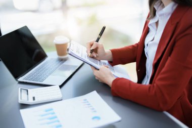 Finansal, Planlama, Pazarlama ve Muhasebe, Asyalı çalışanın portresi Mali durumları kontrol eden Belgeler ve hesap makineleri kullanarak..