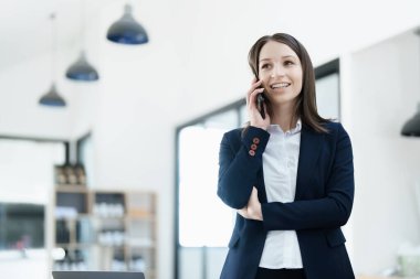 İş yeri sahibi ya da Asyalı kadın pazarlamacılar ofis işlerinde iş telefonlarını kullanıyorlar.