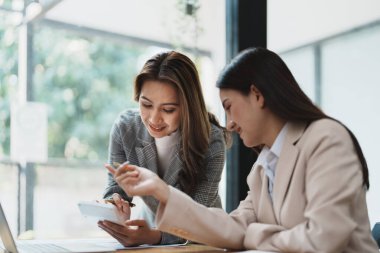 Şirket toplantıları sırasında planlanan yatırım projeleriyle ilgili iş raporlarını analiz eden mali analistler pazarlama planı, bilgisayarlar ve hesap makineleriyle başarılı bir takım çalışması sergilediler..