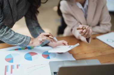 Şirket toplantıları sırasında planlanan yatırım projeleriyle ilgili iş raporlarını analiz eden mali analistler pazarlama planı, bilgisayarlar ve hesap makineleriyle başarılı bir takım çalışması sergilediler..