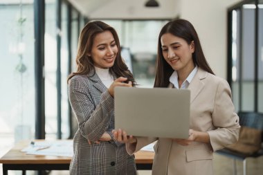 Finansal analistler, şirket toplantıları sırasında planlanan yatırım projeleriyle ilgili iş raporlarını analiz ediyorlar. Pazarlama planıyla başarılı takım çalışması sergiliyorlar, bilgisayarlar çalışıyor.