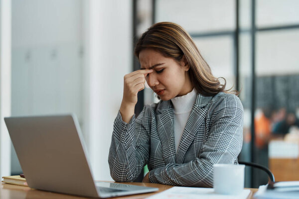 Портрет предпринимателя, женщины, пользующейся компьютером и финансовой отчетностью.