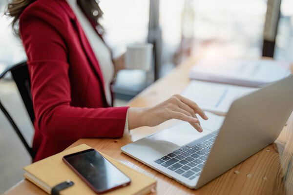 Портрет деловой женщины, разговаривающей за компьютером и пьющей кофе.