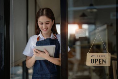 Kafenin önünde elinde tabletle mutlu bir Asyalı kadının portresini aç.