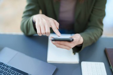 Portrait of a young Asian man showing a smiling face as she uses his phone, computer and financial documents on her desk in the early morning hours.