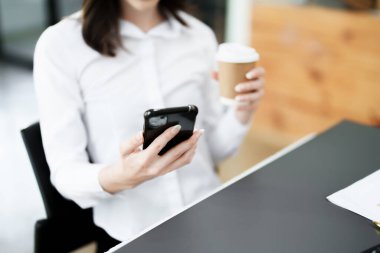 Telefonda konuşan ve kahve içen bir iş kadınının portresi..