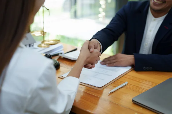 stock image Portrait of a male lawyer shaking hands with a client to settle a court case.