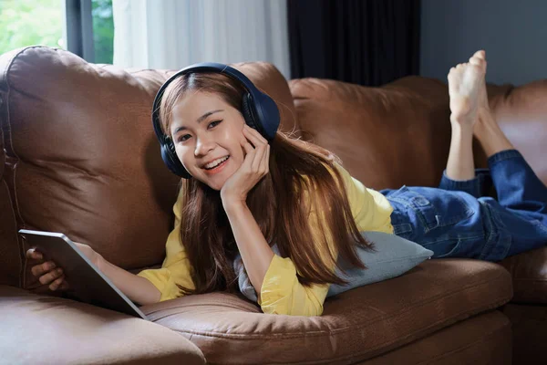 Portrait Asian Woman Using Tablet Headphones Relaxing Sofa Home — Stock Fotó