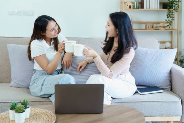 Igbtq, Igbt konsepti, homoseksüellik, iki Asyalı kadının birlikte mutlu poz verip birbirlerini severken koltukta bilgisayar bilgisayarı oynaması..